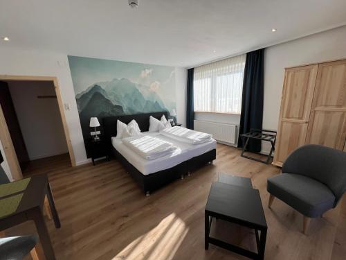 德劳塔尔贝格Hotel Berghof的一间卧室配有一张床、一张沙发和一把椅子