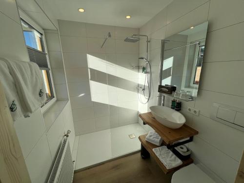 德劳塔尔贝格Hotel Berghof的白色的浴室设有水槽和淋浴。