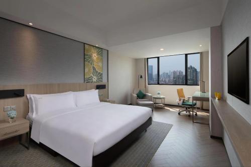 上海上海古井假日酒店的一间带白色大床的卧室和一间客厅