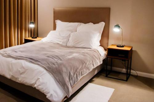 比勒陀利亚408 Trilogy ! EXCELLENT LOCATION ! Menlyn Maine的一间卧室配有一张带白色床单和两盏灯的床。