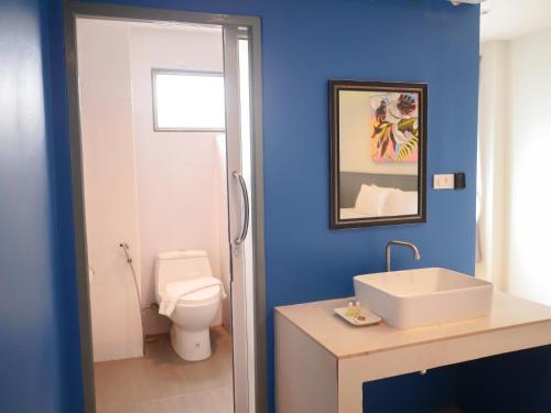 罗勇Xanadu Hotel Utapao的蓝色的浴室设有卫生间和水槽