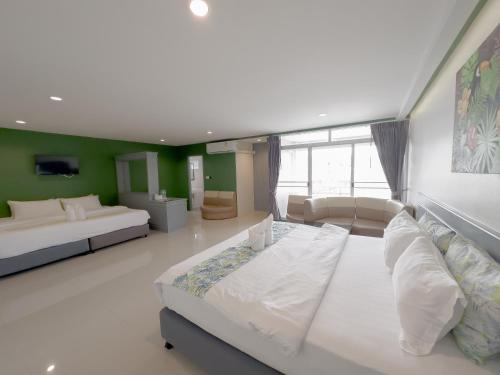 罗勇Xanadu Hotel Utapao的一间带两张床和一张沙发的大卧室