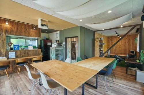富士吉田市MtFuji Guest House Kikkake的一间设有两张木桌和椅子的房间