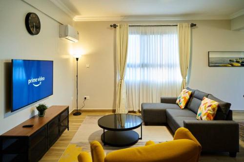 阿鲁沙Westwood Residences的带沙发和电视的客厅