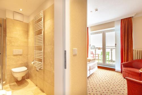 诺德奈Hotel Friese的一间带卫生间的浴室和一间带窗户的房间