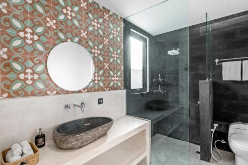 坎古Besso Villa by Hombali的一间带石制水槽和镜子的浴室