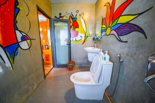 峰牙Phong Nha Escape Bungalow的一间带卫生间的浴室和墙上的绘画