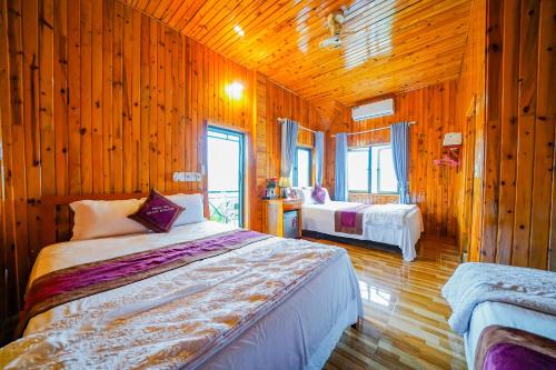 峰牙Phong Nha Escape Bungalow的一间带木墙的卧室和一张位于客房内的床