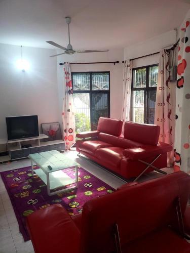 姆万扎Dwina Apartements的客厅配有红色的沙发和桌子