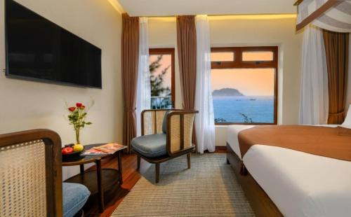 会安HA Hotel Apartments Ocean Front的酒店的客房 - 带一张床、椅子和窗户