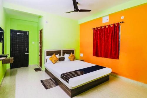 普里Hotel Sand Castle ! Puri的一间卧室配有橙色和绿色墙壁的床