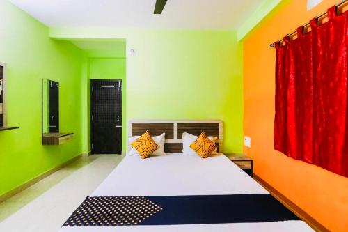 普里Hotel Sand Castle ! Puri的一间卧室设有一张带绿色和橙色墙壁的床。