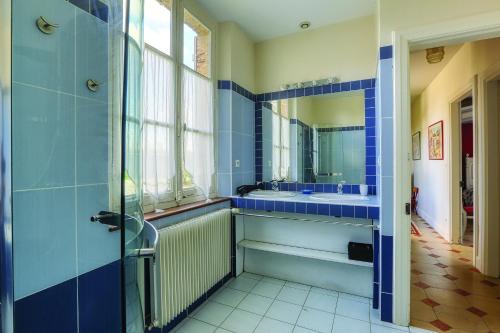 La Goupillère - Ancienne école totalement rénovée的蓝色的浴室设有水槽和镜子