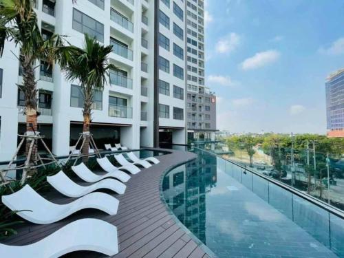 Ấp Phú ThọCompassone - 2bd Luxury Apartment Free Gym & Pool的一条带白色椅子的走道和一座建筑