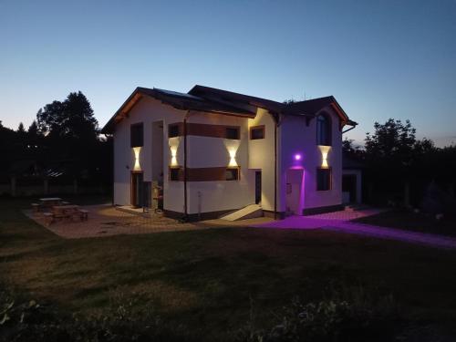 瑟切莱MONADIN Villa Relax & Spa的白色的小房子,上面有紫色的灯