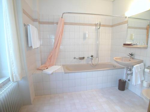 格拉鲁斯Hotel Post Glarnerhof的带浴缸和盥洗盆的浴室