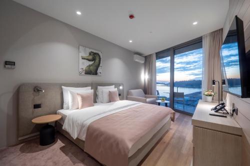 布德瓦Sea Star Budva的一间卧室设有一张大床和一个大窗户
