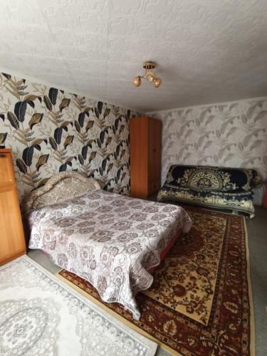 卡拉甘达Уютная квартира в центре города的一间小卧室,配有床和地毯
