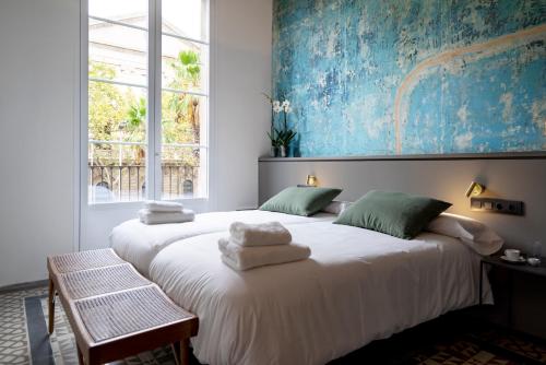 巴塞罗那Hostal Porxos Garden的一间卧室配有两张带毛巾的床