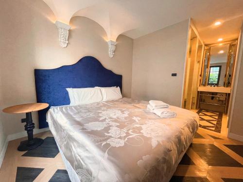 南芭堤雅Espana Vacation Residence Jomtien & Yahaha的一间卧室配有一张大床和蓝色床头板