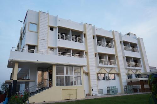 普鲁利耶Swet Palash Resort的一座大型白色建筑,设有阳台