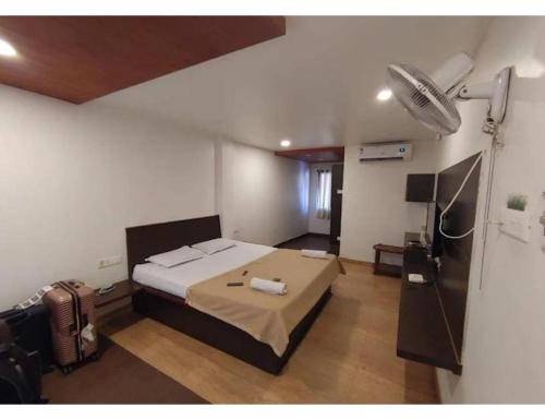 布莱尔港Sea Lounge, Port Blair的一间卧室配有一张床和一个风扇