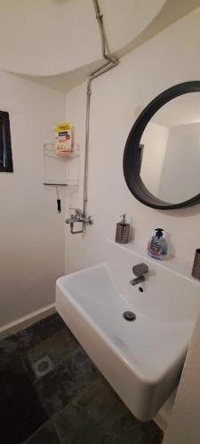 罗德镇The Retreat in the heart of Old Town Rhodes的浴室设有白色水槽和镜子
