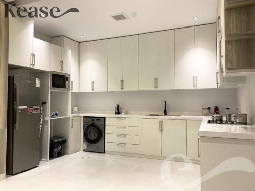 利雅德Kease Nafal C-4 Royal touch AZ46的厨房配有白色橱柜和洗碗机。
