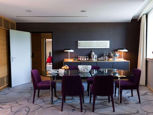 卢森堡索菲特的一间带桌子和紫色椅子的用餐室