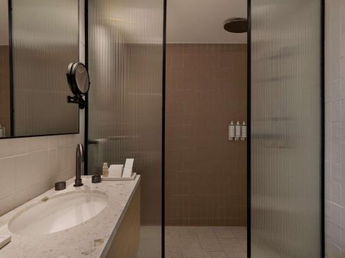 特拉维夫Elkonin Tel Aviv - MGallery Hotel Collection的一间带水槽和淋浴的浴室