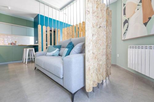 马德里Estudio moderno y acogedor en Madrid Rio nº3的一间带蓝色沙发的客厅和一间厨房