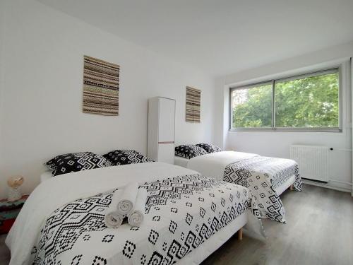 科隆布Chic and comfortable apart near Paris的一间卧室设有两张床和窗户。