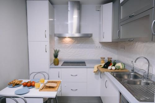 哈恩Piso compartido Delyrent, Reja的厨房配有白色橱柜和水槽