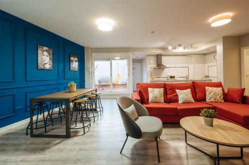 塞维利亚森特拉尔套房公寓的客厅配有红色的沙发和桌子