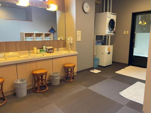 秋田秋田市土崎路线酒店的浴室设有2个水槽和2个凳子