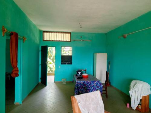 OuidahAppat'Adjanohoun的一间设有桌子和蓝色墙壁的客房