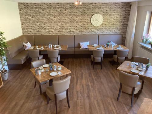 梅德巴赫Pension Orketal的餐厅设有木桌和椅子,拥有砖墙