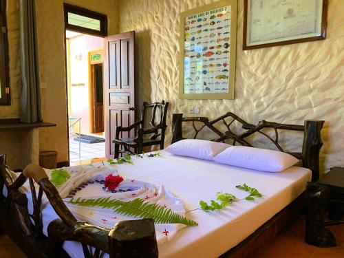 妮兰朵南环礁Villa Stella, Rinbudhoo的一间卧室,床上放着鲜花