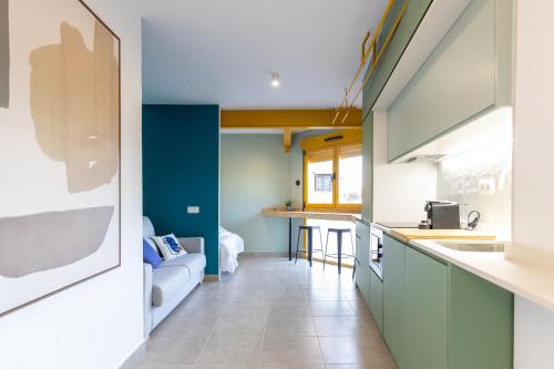 马德里Estudio moderno y acogedor en Madrid Rio nº 9的厨房设有绿色橱柜和蓝色的墙壁
