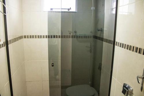 弗洛里亚诺波利斯Otimo apto 9 min do aeroporto em Florianopolis SC的浴室设有玻璃淋浴间和卫生间