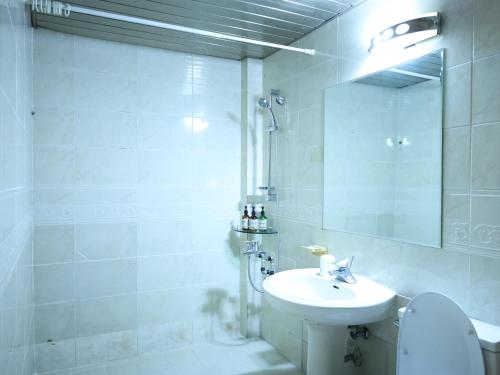 安东市安东公园良宿酒店的白色的浴室设有水槽和卫生间。