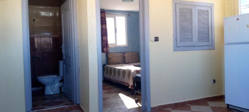 依索安Villa de l'ermitage的走廊上设有一间卧室,卧室内配有一张床和一个窗户
