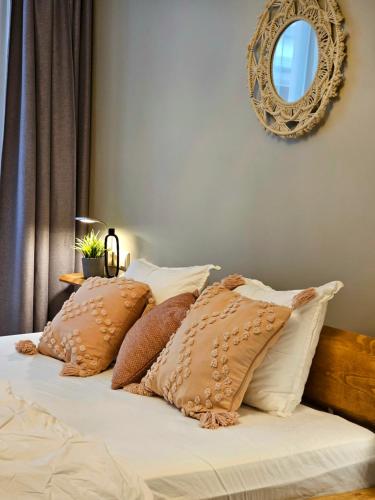 里加Silversmith's Residence in Old Riga的一张带棕色和白色枕头的床和镜子