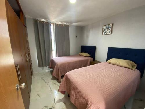 瓜达拉哈拉Casa duplex aeropuerto/arena VFG的客房设有两张带粉色床单的床和窗户。