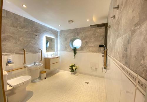 蒂贝Lune Cottage nestled between Lake District and Yorkshire Dales的一间带卫生间、水槽和镜子的浴室