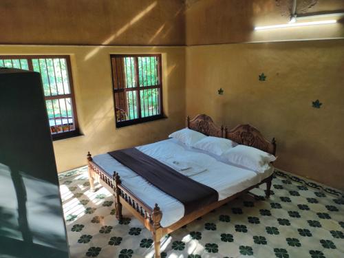 KodaliChithira Homestay (Kerala traditional mud house)的一间设有床铺的卧室,位于带窗户的房间内
