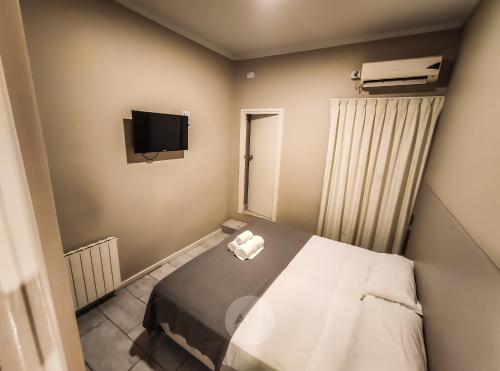 圣胡安Hotel Alhambra的小房间设有床铺和电视