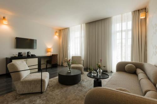 蒂米什瓦拉蒂米什瓦拉酒店的客厅配有沙发、椅子和电视