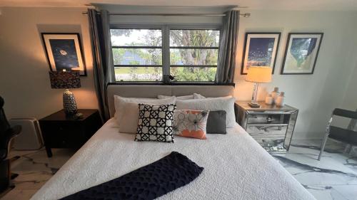 劳德代尔堡Paradise Gardens-Wilton Manors-Clothing Optional- Male only的卧室配有带枕头的床铺和窗户。