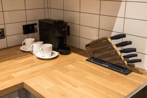 利兹Kirkgate Suites - Majestic City Centre Apartment的带杯子和咖啡壶的厨房台面